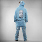 Person wearing a blue tracksuit with a character design on the back against a gray background
