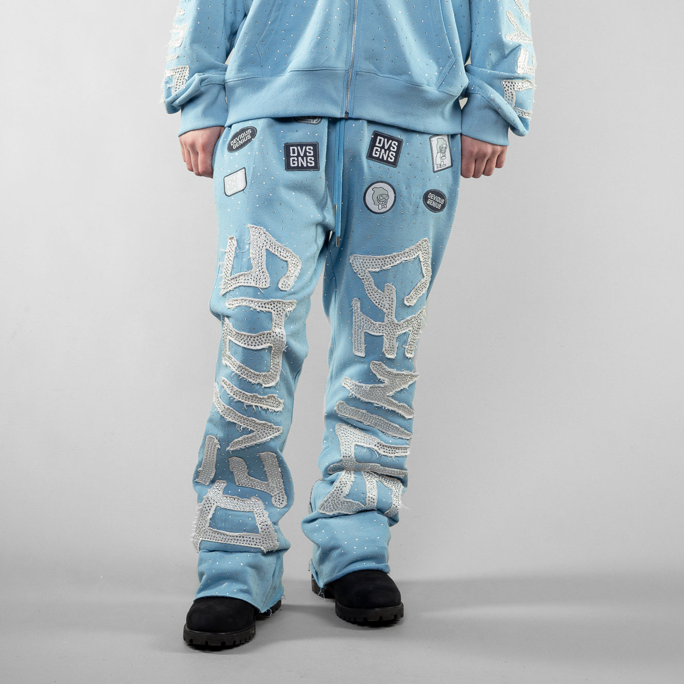 Light blue tracksuit with rhinestone text on a gray background