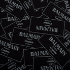 Multiple Balmain labels scattered on a black background