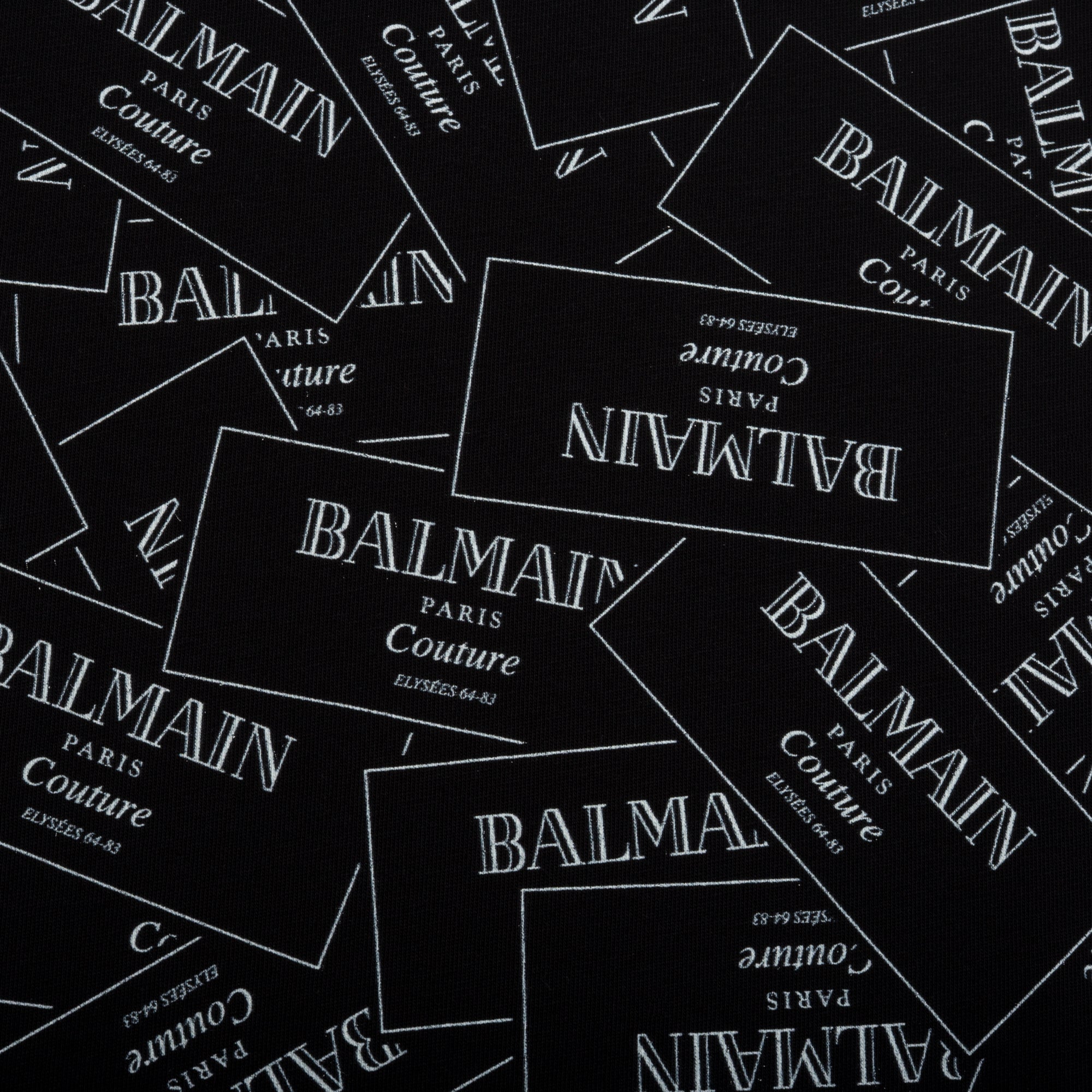 Multiple Balmain labels scattered on a black background